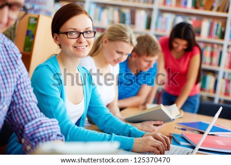 Group of modern students working together in library