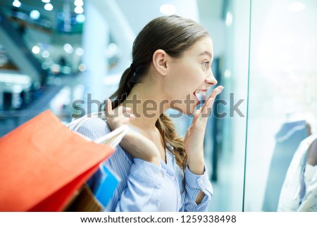 Young shopper with wow expression looking at something really amazing in shop window