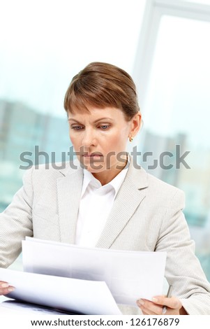 Photo of smart businesswoman working with papers in office