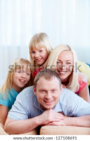 Portrait of happy family of four looking at camera with smiles