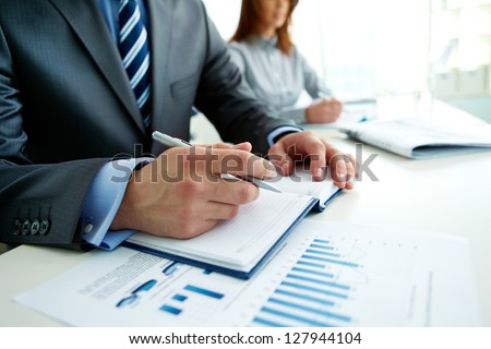 Image Of Male Hand With Pen Over Page Of Notebook At Seminar