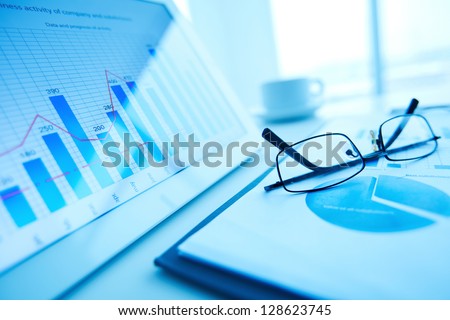 Image of workplace with paper and electronic documents and eyeglasses