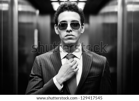 Portrait of confident man in suit and sunglasses looking at camera