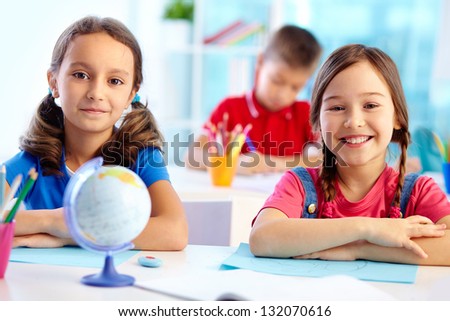 Portrait of cute school girls sitting at their desk Portrait of cute school girls sitting at their desk