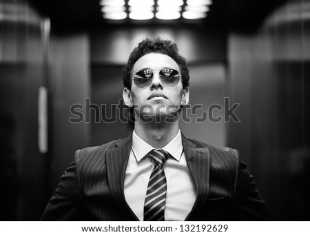Black-And-White Portrait Of An Ambitious Business Guy Wearing Sunglasses