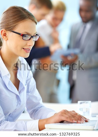 Vertical shot of a positive office worker computing in office