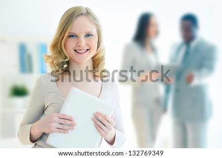 Portrait of a lovely business intern holding a touchpad