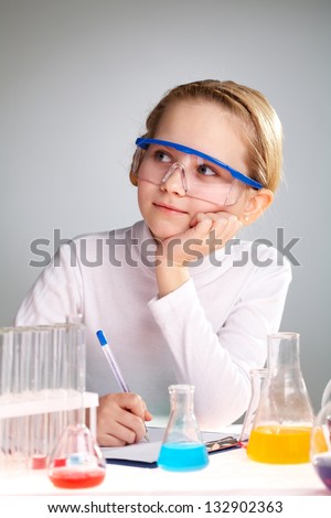 Vertical image of a cute girl dreaming of a scientific discovery in the lab