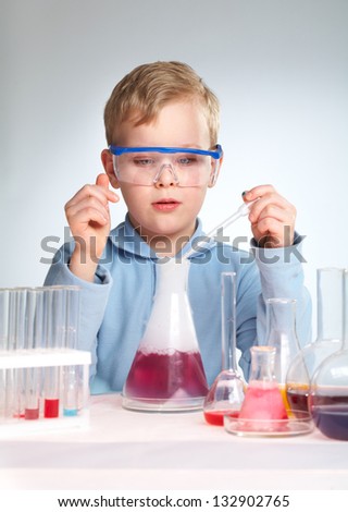 Vertical shot of a school scientist being curious about chemical reaction