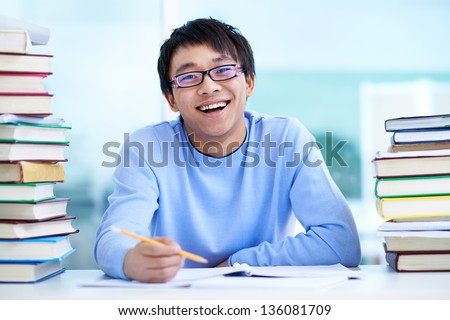 Portrait of successful Asian student sitting at workplace