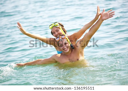 Friends in scuba masks having fun in summer water