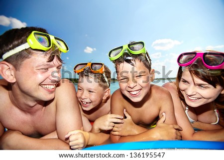 Photo of happy family looking at camera during summer recreation