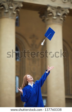 Portrait of joyful student throwing graduation hat