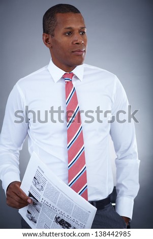 Portrait of successful professional in formalwear holding newspaper