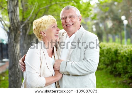 Happy mature woman looking at her husband while both laughing outside