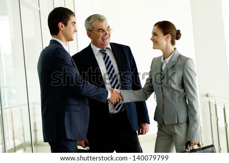 Image of business partners handshaking after striking deal