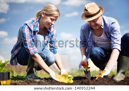 Image of couple of farmers seedling sprouts in the garden