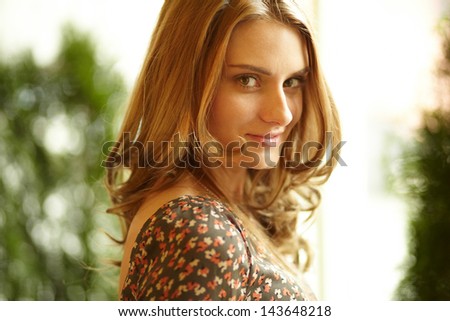 Close-up shot of a gorgeous beauty with curly hair and flirty look