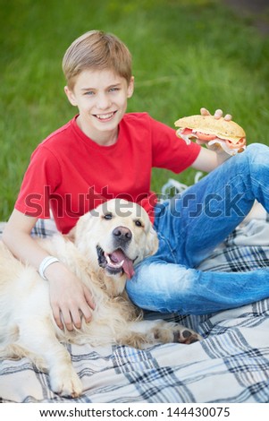 Portrait of cute lad and his fluffy friend on a picnic