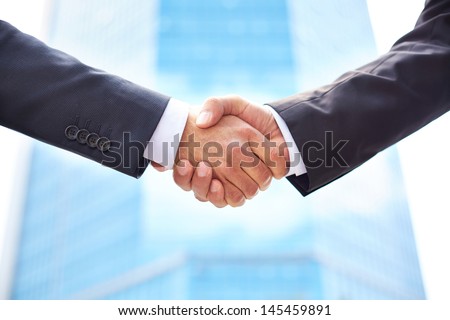 Close-Up Of Business Partners Shaking Hands To Do Business Together