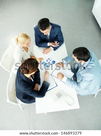 Above view of successful partners during negotiations at meeting
