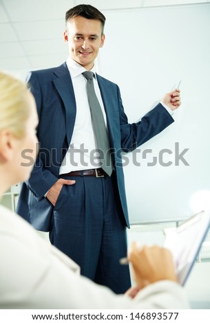 A business man showing something to his co-worker on a whiteboard