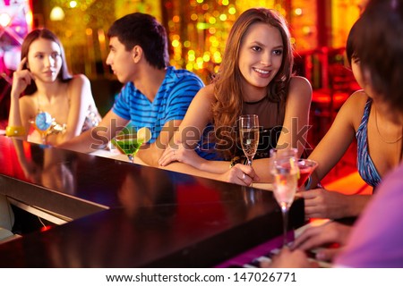 Portrait of pretty girls talking at party in the bar