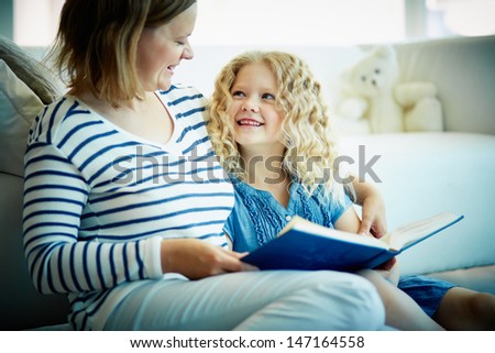 Portrait Of Cute Girl Listening To Her Mother Telling An Interesting Story At Home