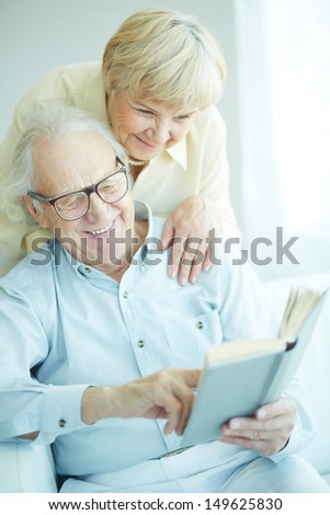 Portrait Of A Candid Senior Couple Reading Book Together