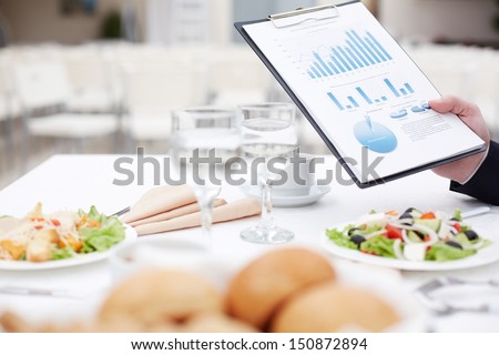 Close-up of business document in male hand during business lunch