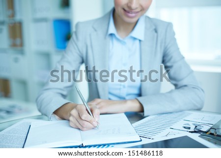 Office lady writing down a week plan in her organizer
