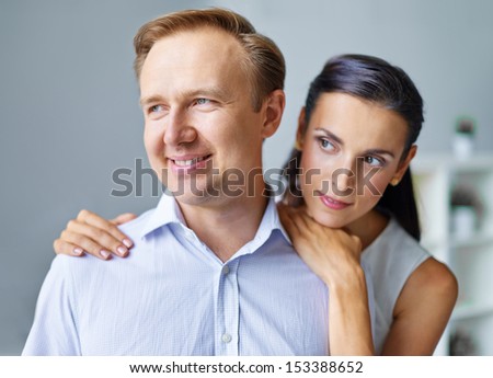Portrait of middle aged man being embraced by his wife