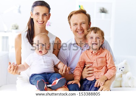 Portrait of happy family with cute sons looking at camera