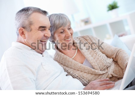Portrait of mature man and his wife working with laptop at home