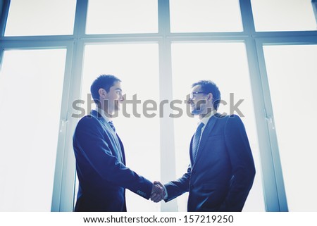 Photo of successful businessmen handshaking after striking deal