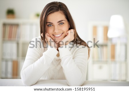 Happy girl in white pullover looking at camera with smile