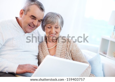 Portrait Of Mature Man And His Wife Working With Laptop At Home