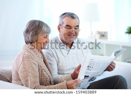 Portrait of mature couple reading newspaper together