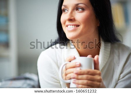 Portrait of happy brunette with mug in hands