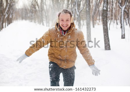 Portrait of happy guy in winterwear having fun in park