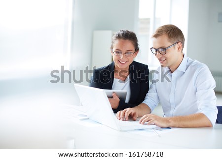 Portrait Of Businessman And Businesswoman Looking At Laptop Display At Meeting