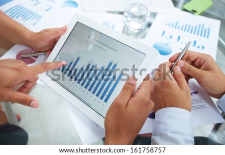 Close-up of businessman holding electronic document in touchpad and pointing at it during discussion