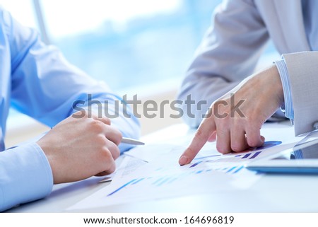 Close-Up Of Female Hand Pointing At Business Document In Working Environment