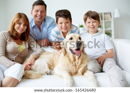Portrait of happy family with their pet having rest at home