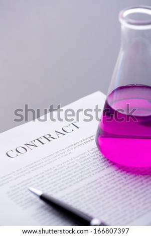 Test-tube with purple liquid over paper agreement