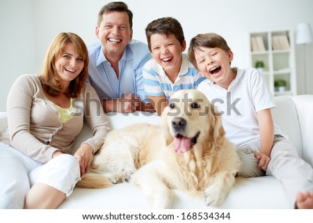 Portrait Of Happy Family With Their Pet Having Good Time At Home