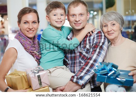 Portrait of happy family looking at camera after shopping