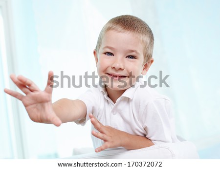 Little boy reaching out towards the camera