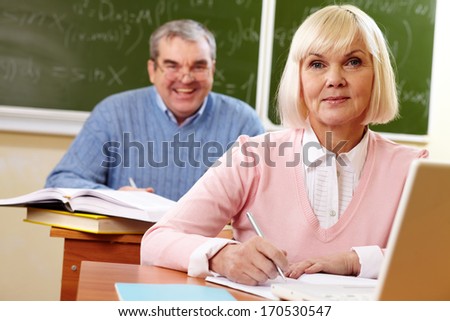 Two senior people at the lesson looking at camera and smiling