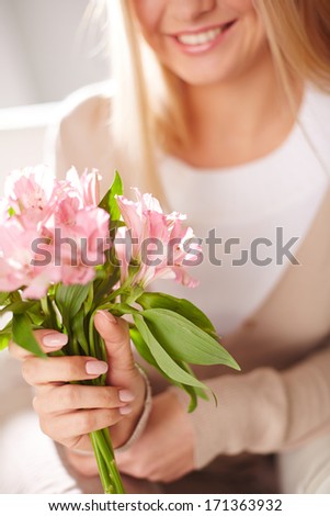 Close-up of smiling female holding bunch of pink lilies